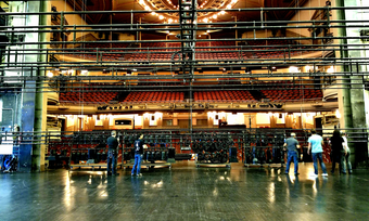 a backstage crew in the process of hanging lights in a theatre