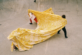 three dancers under a yellow sheet