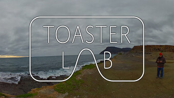 Person on a mountain by water, overlaid with the Toaster Lab logo