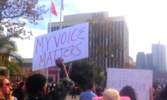 a person holding a sign that says "my voice matters"