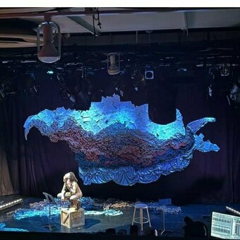 sculpture floating above a theatrical stage.