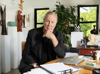 portrait of robert wilson sitting at a desk.