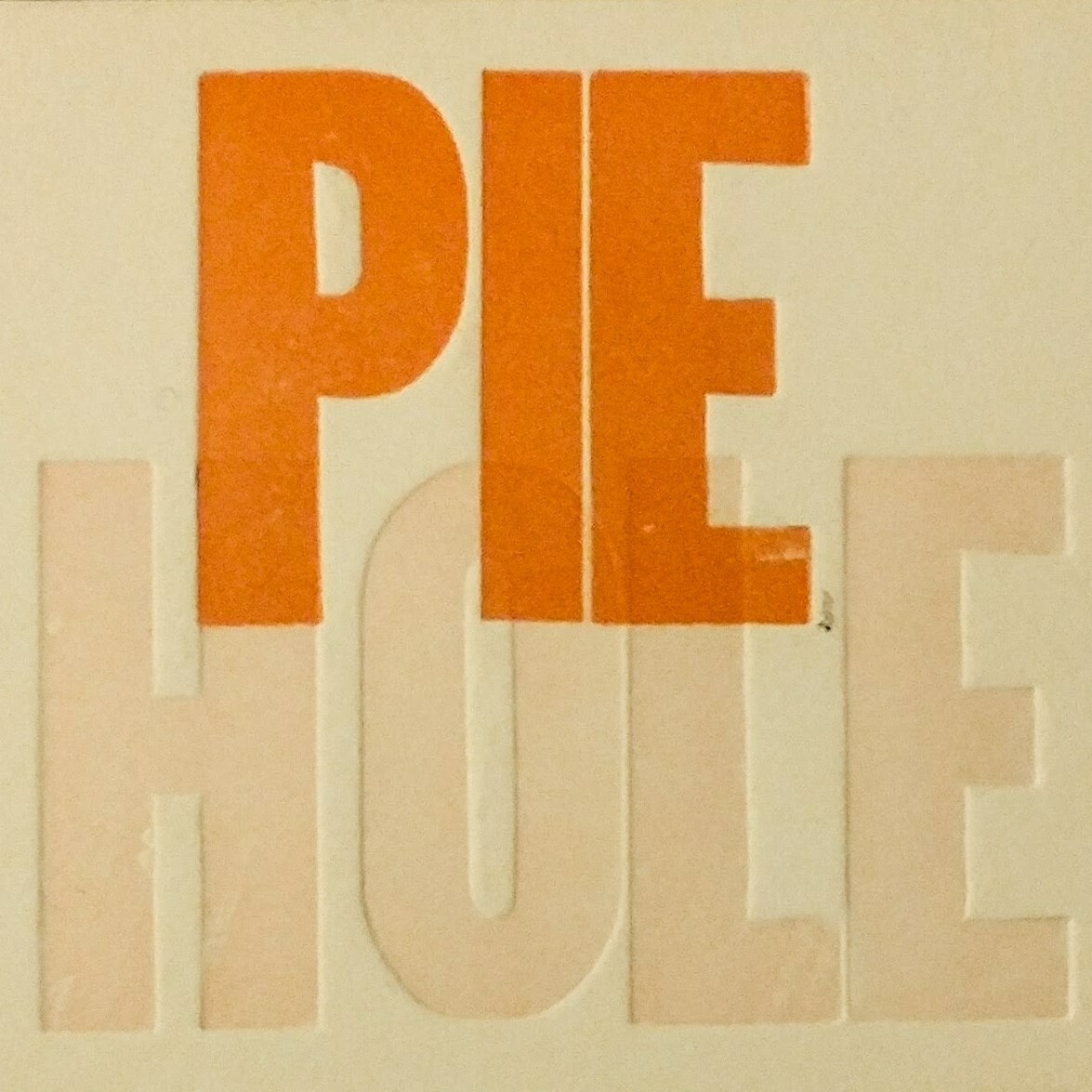 orange and tan text PIE HOLE over tan background.