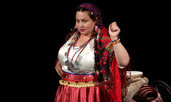Roma woman in traditional clothes on stage.