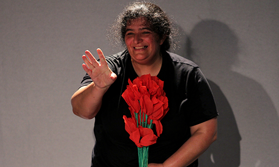 A woman holding a bouquet of red flowers. 