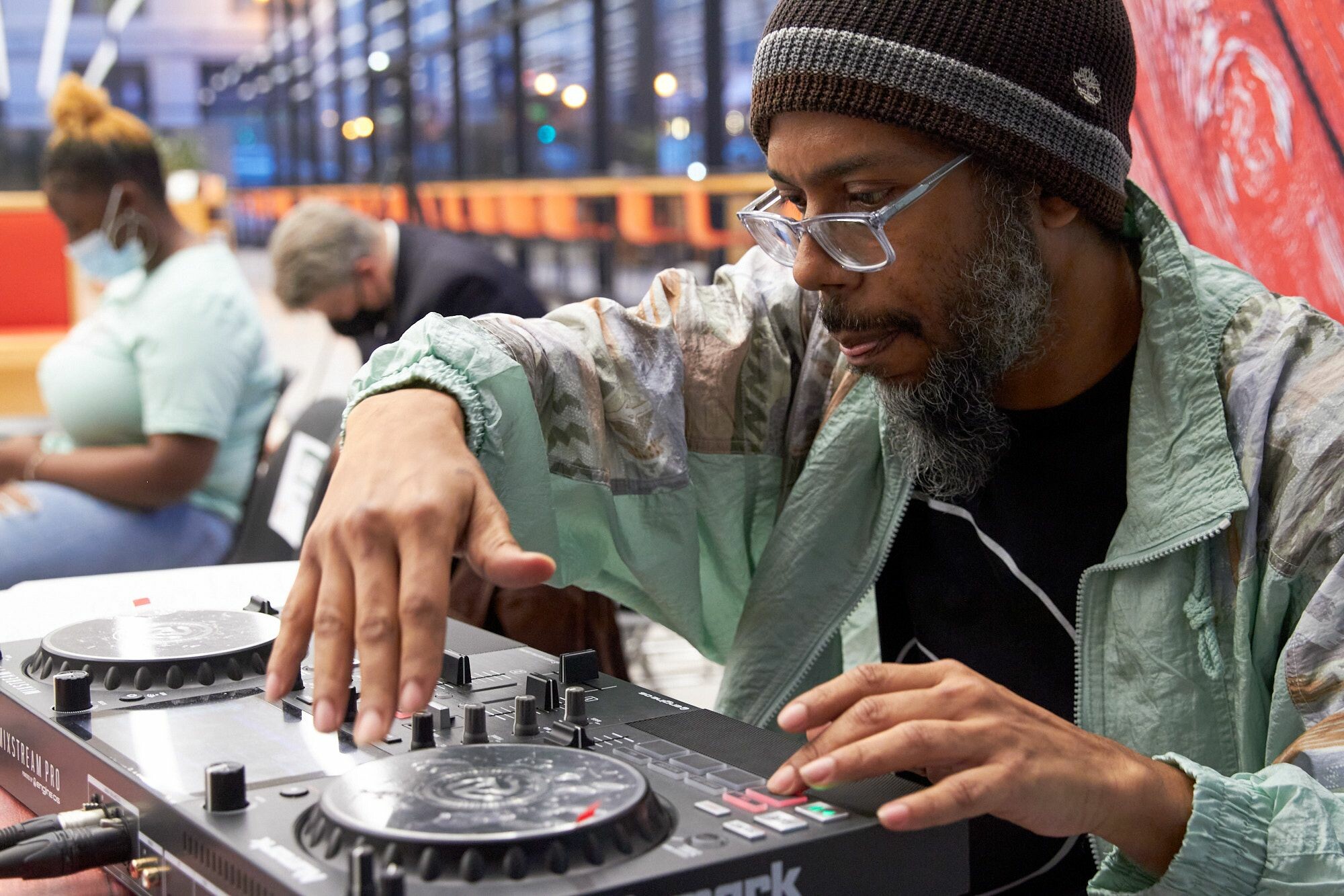 A man leans over his DJ set and concentrates during a performance.