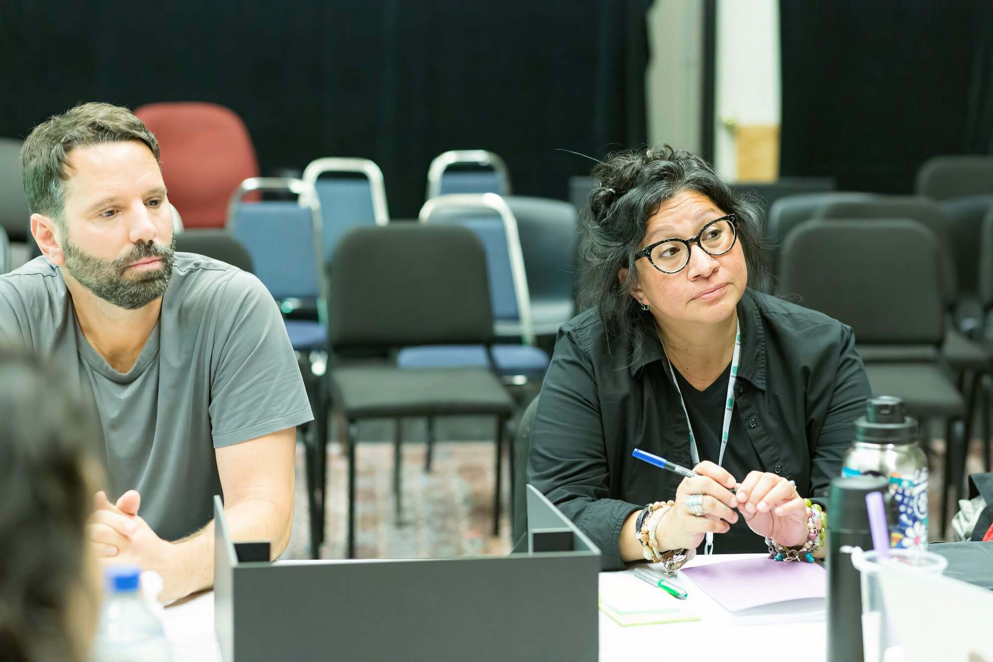 Two Artists sit at a table speaking at a workshop.