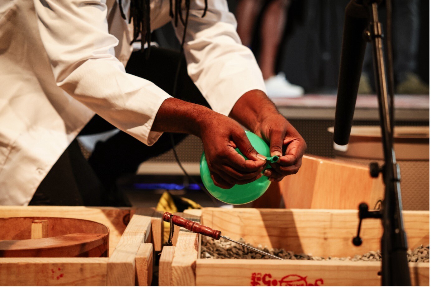 An artists makes use of a foley table in front of a microphone.