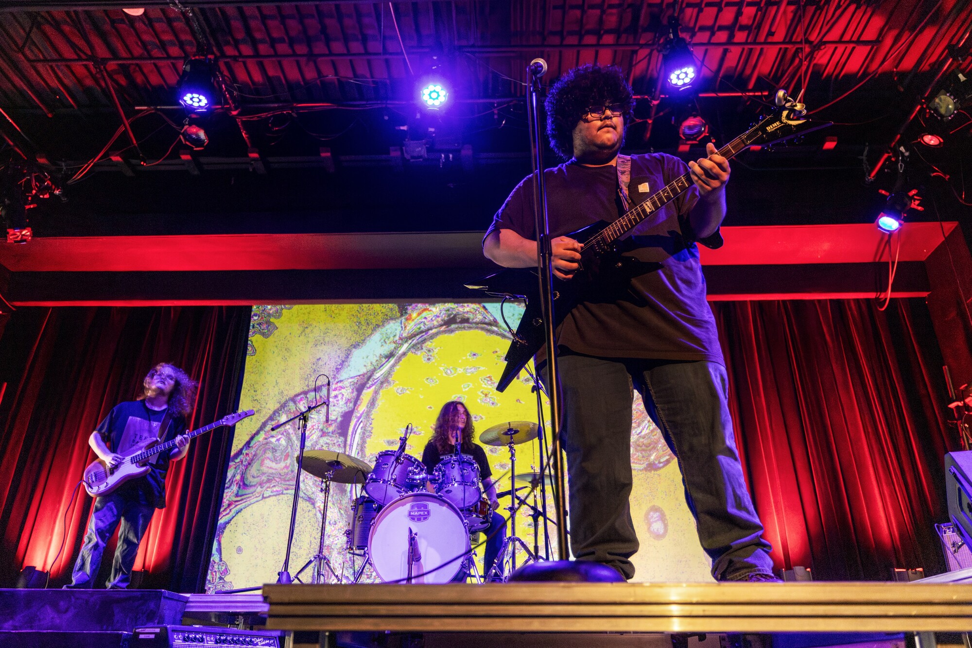 A student rock band performs onstage.