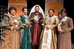 Five performers in period dresses stand on stage holding flower bouquets in Constant Star.